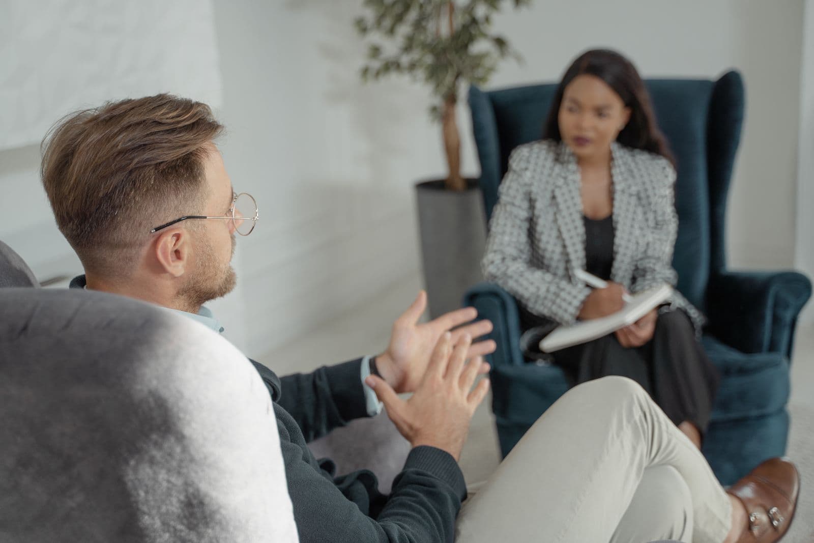 Assistant taking notes with a principal in a refined sitting room