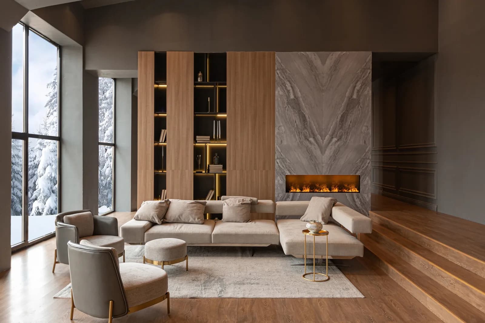 A living room with a lit marble fireplace, a low sectional sofa and a wood panelled bookcase wall